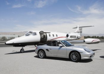 Convertible silver Porsche parked by private jet birthday card